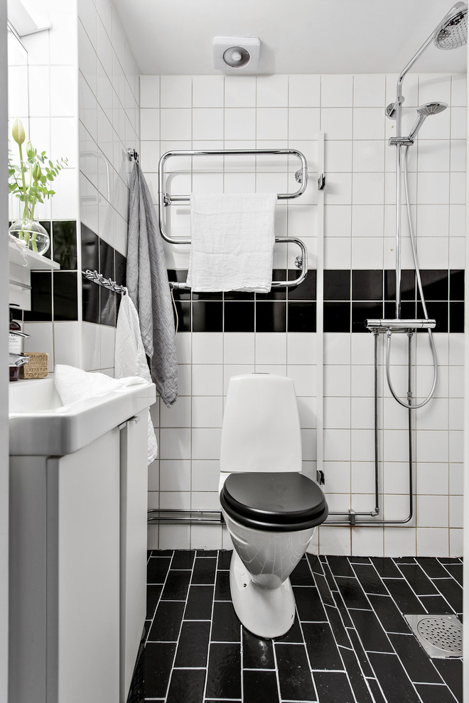 Photo of a scandi shower room bathroom in Gothenburg with flat-panel cabinets, white cabinets, a walk-in shower, a two-piece toilet, black and white tiles, white walls, black floors and an open shower.