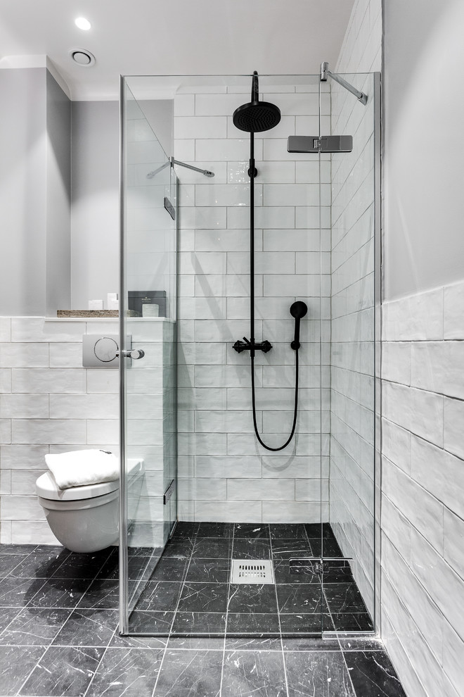 Nordisk inredning av ett badrum, med en hörndusch och en vägghängd toalettstol