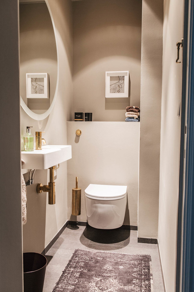 Inspiration för små moderna badrum, med en vägghängd toalettstol, beige väggar, ett väggmonterat handfat, öppna hyllor och kalkstensgolv