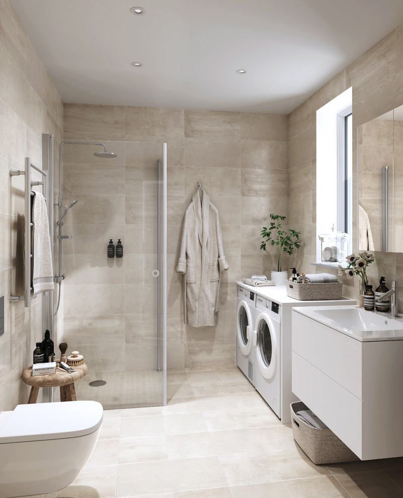 Inspiration for a medium sized scandinavian bathroom in Other with flat-panel cabinets, white cabinets, beige tiles, a corner shower, a one-piece toilet, beige walls, a wall-mounted sink, beige floors and a laundry area.