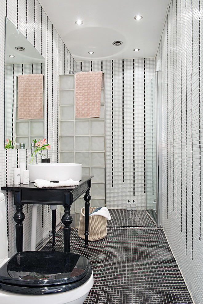 Идея дизайна: ванная комната среднего размера в стиле неоклассика (современная классика) с душем без бортиков, унитазом-моноблоком, черной плиткой, белой плиткой, плиткой мозаикой, белыми стенами, полом из мозаичной плитки, настольной раковиной и душем с распашными дверями