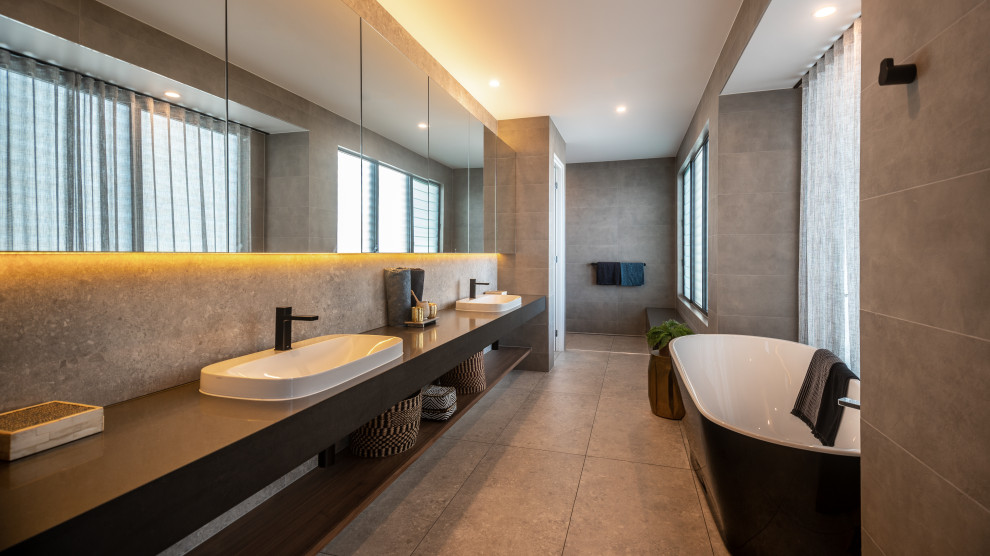 Aménagement d'une salle de bain principale contemporaine de taille moyenne avec un placard sans porte, une baignoire indépendante, un carrelage gris, une vasque, un sol gris, un plan de toilette gris, meuble double vasque et meuble-lavabo suspendu.