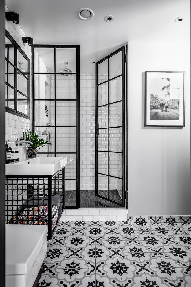 Foto på ett mellanstort industriellt badrum, med öppna hyllor, svarta skåp, vit kakel, tunnelbanekakel, vita väggar, klinkergolv i keramik, ett nedsänkt handfat, flerfärgat golv och dusch med gångjärnsdörr