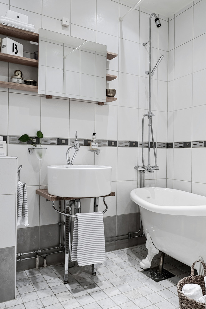 Inspiration för skandinaviska badrum med dusch, med öppna hyllor, en dusch/badkar-kombination, vita väggar, ett fristående handfat, träbänkskiva, grått golv, ett badkar med tassar, vit kakel och dusch med duschdraperi