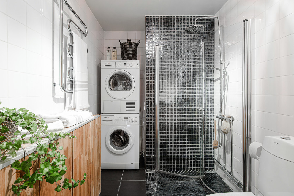 Esempio di una stanza da bagno con doccia scandinava con doccia ad angolo, WC monopezzo, piastrelle grigie, piastrelle bianche, pavimento nero, porta doccia a battente e lavanderia