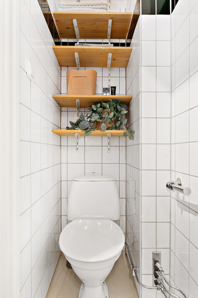 Idéer för att renovera ett litet nordiskt badrum, med öppna hyllor, skåp i mellenmörkt trä, en toalettstol med separat cisternkåpa, vita väggar och keramikplattor