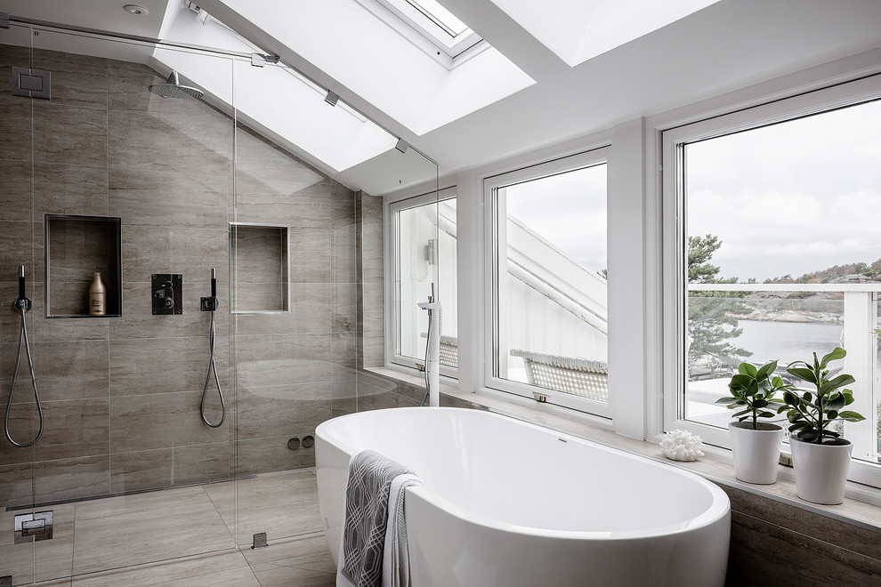 На фото: большая ванная комната в скандинавском стиле с бежевой плиткой, коричневой плиткой, серыми стенами, душевой кабиной, отдельно стоящей ванной, душем без бортиков, коричневым полом и душем с распашными дверями с