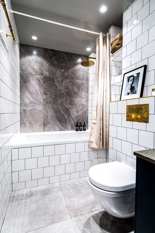 Modelo de cuarto de baño gris y blanco minimalista de tamaño medio con combinación de ducha y bañera, sanitario de pared, baldosas y/o azulejos grises, baldosas y/o azulejos blancos, paredes blancas, aseo y ducha, suelo gris y ducha con cortina