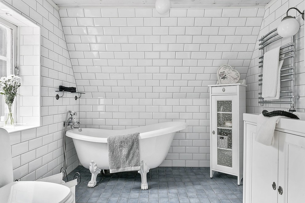Inspiration for a vintage bathroom in Gothenburg with white cabinets, a freestanding bath and a shower/bath combination.