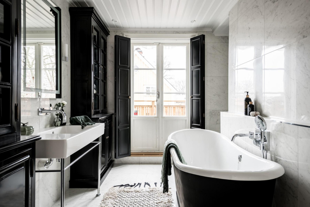Idéer för att renovera ett minimalistiskt badrum, med ett fristående badkar, vit kakel, ett konsol handfat och vitt golv