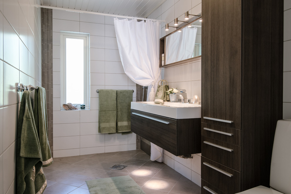 Exempel på ett modernt vit vitt badrum med dusch, med släta luckor, bruna skåp, en toalettstol med separat cisternkåpa, vit kakel, ett integrerad handfat, grått golv och med dusch som är öppen