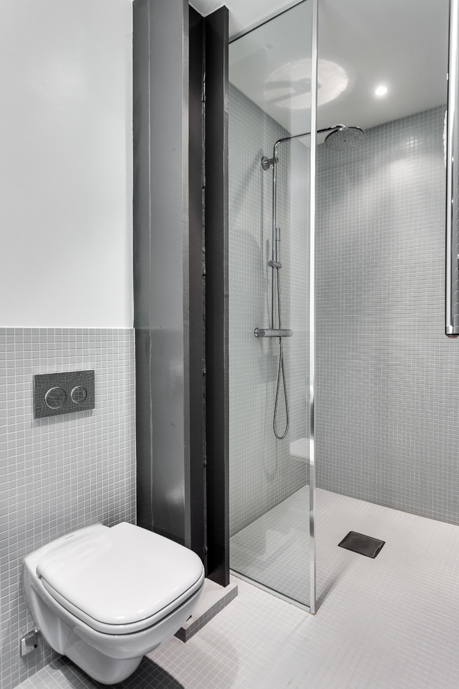 Idéer för ett industriellt badrum, med en hörndusch, grå kakel, mosaik och en vägghängd toalettstol