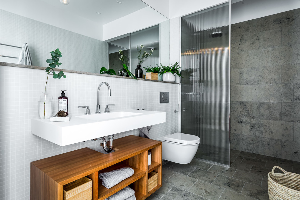 Idéer för mellanstora skandinaviska badrum med dusch, med öppna hyllor, skåp i mellenmörkt trä, en vägghängd toalettstol, grå kakel, mosaik, grått golv, en dusch i en alkov, vita väggar, ett konsol handfat och med dusch som är öppen