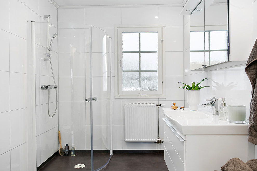 Cette photo montre une salle de bain principale scandinave de taille moyenne avec un placard à porte plane, des portes de placard blanches, une douche d'angle, un carrelage blanc, un mur blanc, des carreaux de porcelaine et un lavabo posé.
