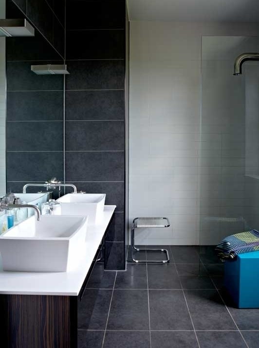 Modernes Badezimmer mit verzierten Schränken, dunklen Holzschränken, offener Dusche, grauen Fliesen, Keramikfliesen, Keramikboden, Aufsatzwaschbecken und Quarzwerkstein-Waschtisch in London