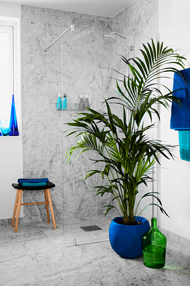 Cette image montre une grande salle d'eau minimaliste avec une douche d'angle, un carrelage gris, un mur gris et un sol en marbre.