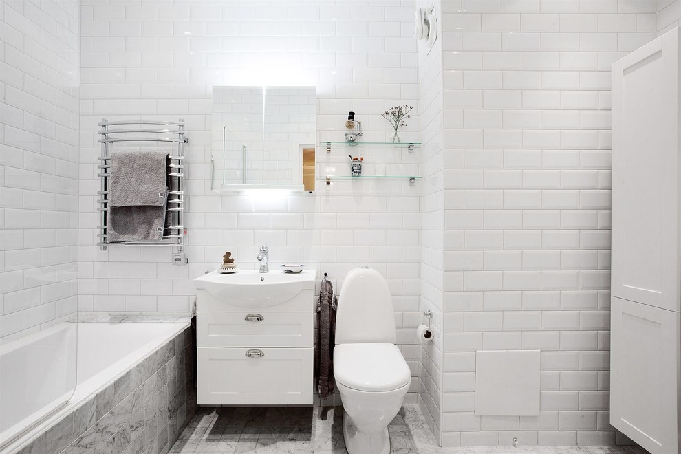 Inspiration för ett stort minimalistiskt badrum, med skåp i shakerstil, vita skåp, ett badkar i en alkov, en dusch/badkar-kombination, en toalettstol med separat cisternkåpa, vita väggar, marmorgolv, ett konsol handfat och tunnelbanekakel