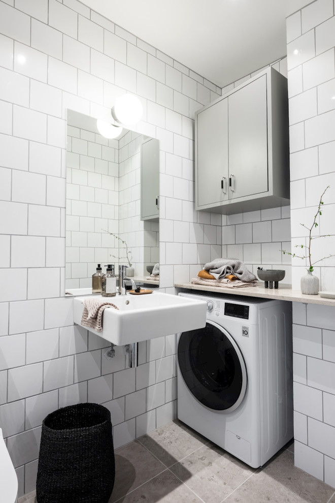 Kleines Modernes Duschbad mit weißen Fliesen, Porzellanfliesen, Porzellan-Bodenfliesen, integriertem Waschbecken, grauem Boden und Einzelwaschbecken in Göteborg