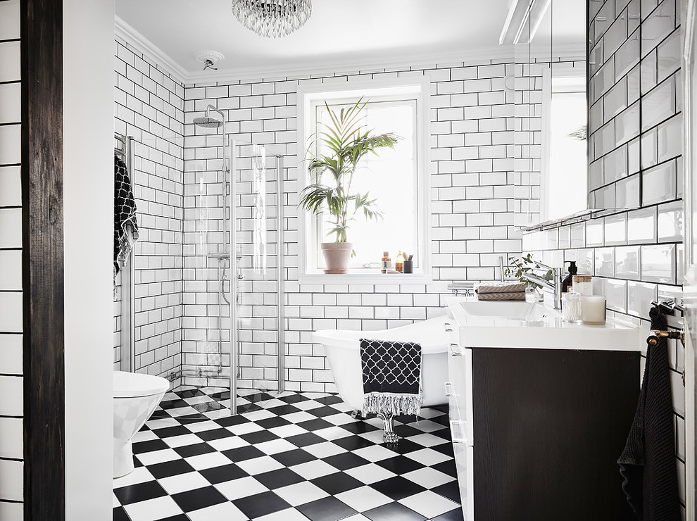 ヨーテボリにあるトラディショナルスタイルのおしゃれな浴室 (置き型浴槽、白い壁、マルチカラーの床) の写真