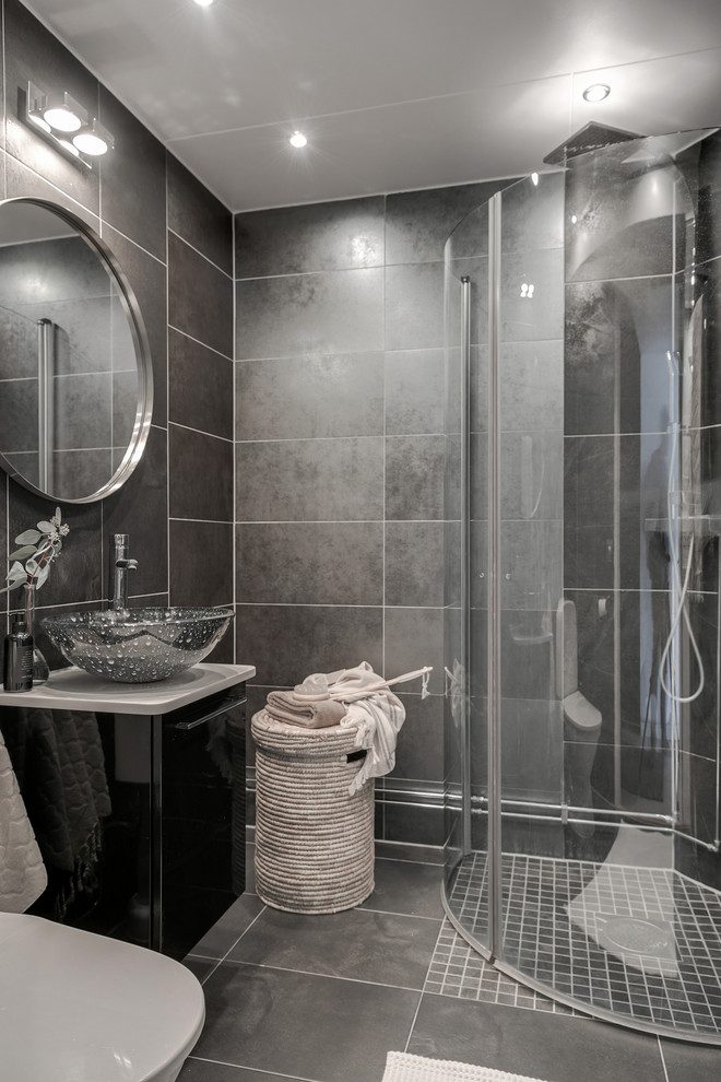 Foto di una stanza da bagno con doccia scandinava di medie dimensioni con ante lisce, ante nere, doccia ad angolo, piastrelle grigie, pareti grigie, lavabo a bacinella, pavimento grigio e porta doccia a battente