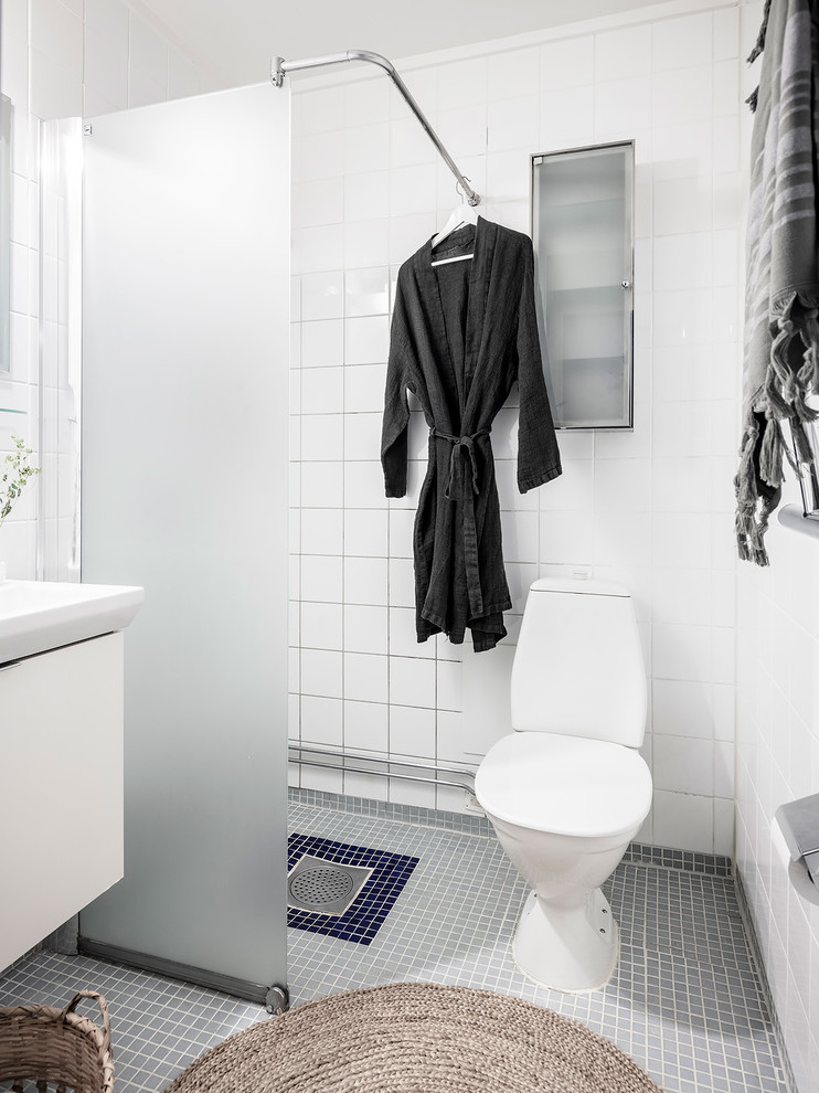 Idéer för att renovera ett minimalistiskt vit vitt badrum med dusch, med släta luckor, vita skåp, en hörndusch, en toalettstol med hel cisternkåpa, vit kakel, vita väggar, mosaikgolv, ett konsol handfat, grått golv och med dusch som är öppen
