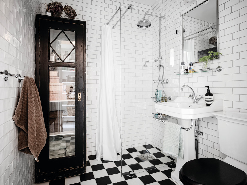 Inspiration for a scandinavian shower room bathroom in Gothenburg with a corner shower, a two-piece toilet, white tiles, metro tiles, white walls, a pedestal sink, multi-coloured floors and an open shower.