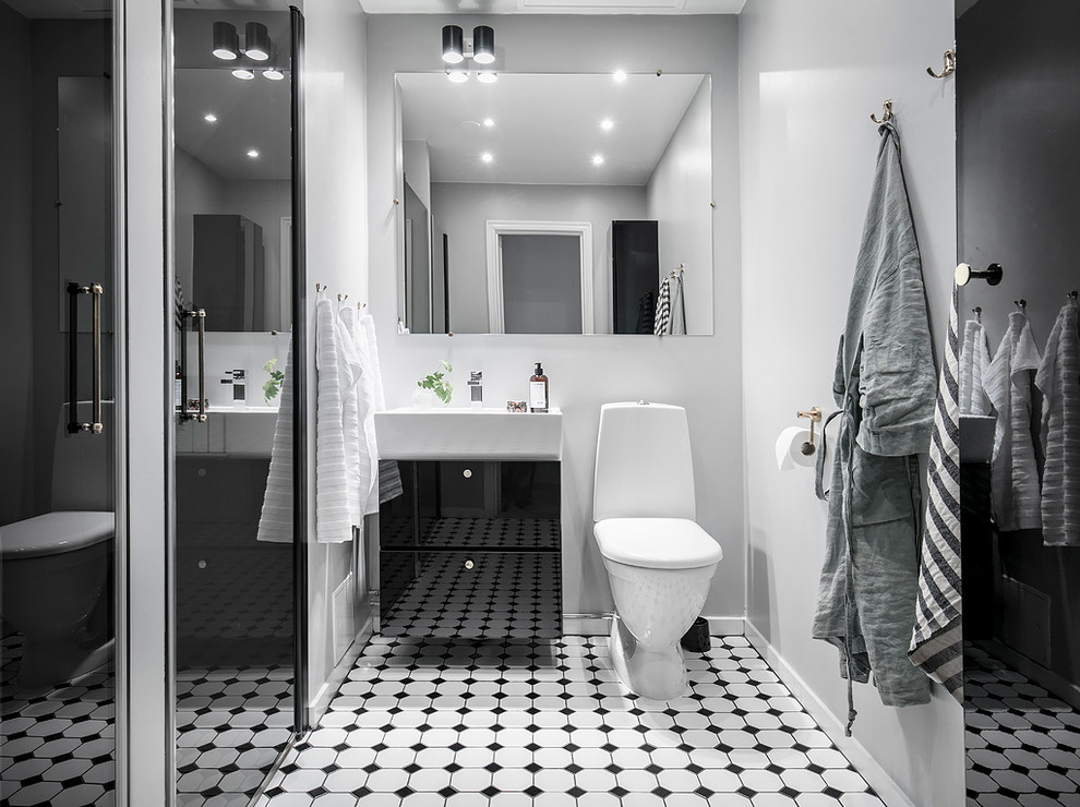 Inspiration för mellanstora minimalistiska badrum med dusch, med släta luckor, svarta skåp, en toalettstol med hel cisternkåpa, vita väggar, flerfärgat golv, en dusch i en alkov, cementgolv, ett konsol handfat och dusch med gångjärnsdörr