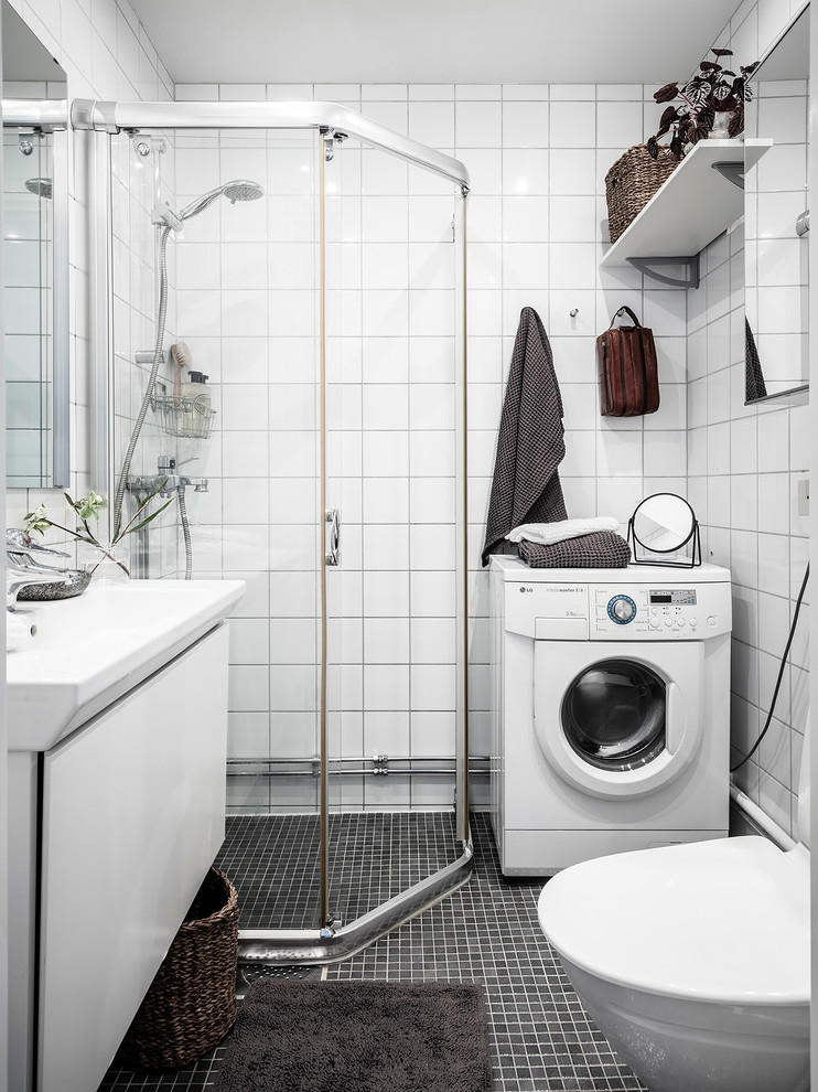 Skandinavisk inredning av ett badrum, med en hörndusch och dusch med gångjärnsdörr
