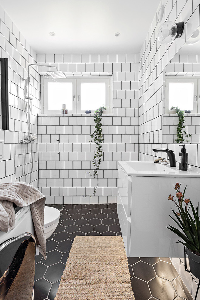 Medium sized scandinavian shower room bathroom in Stockholm with flat-panel cabinets, white cabinets, a walk-in shower, white tiles, quartz worktops and black floors.