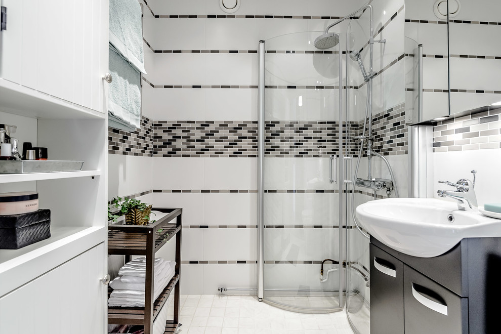ストックホルムにある高級な中くらいなコンテンポラリースタイルのおしゃれなバスルーム (浴槽なし) (白いキャビネット、コーナー設置型シャワー、グレーのタイル、オーバーカウンターシンク、サブウェイタイル、白い壁、磁器タイルの床) の写真