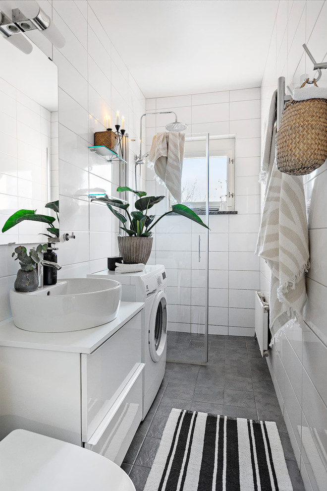 Идея дизайна: ванная комната со стиральной машиной в скандинавском стиле с плоскими фасадами, белыми фасадами, душем в нише, белой плиткой, настольной раковиной, серым полом и белой столешницей
