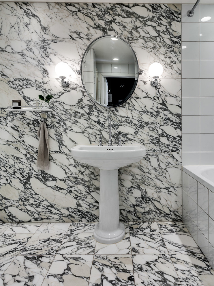 Klassisk inredning av ett mellanstort badrum, med svart och vit kakel, flerfärgade väggar, ett piedestal handfat, ett platsbyggt badkar, marmorgolv och dusch med duschdraperi