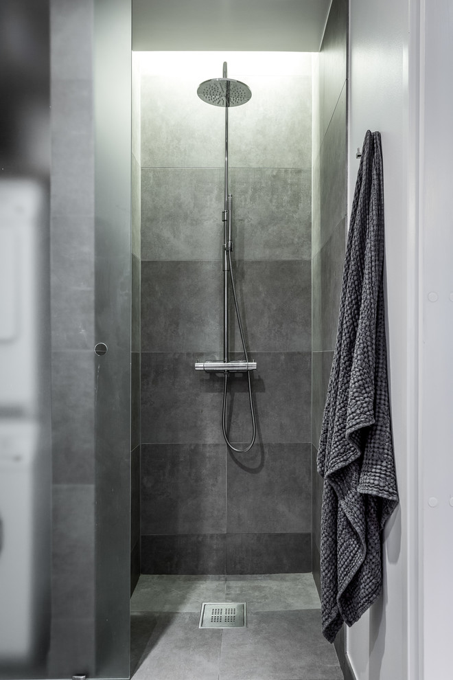 Inspiration pour une douche en alcôve nordique avec un carrelage gris et une cabine de douche à porte coulissante.