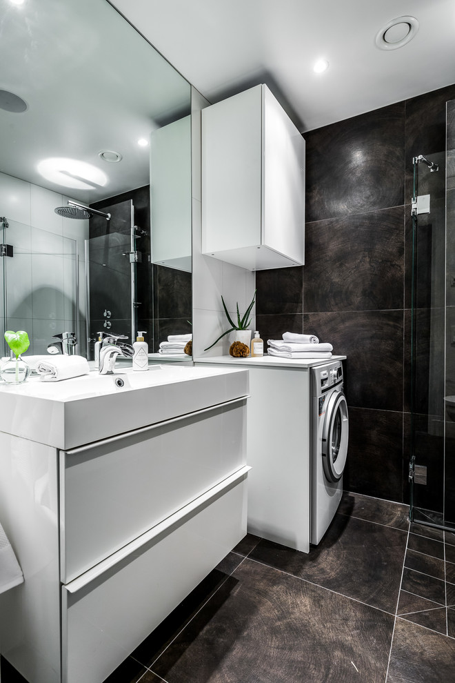Bild på ett mellanstort funkis badrum med dusch, med släta luckor, vita skåp, brun kakel, svart kakel och brunt golv