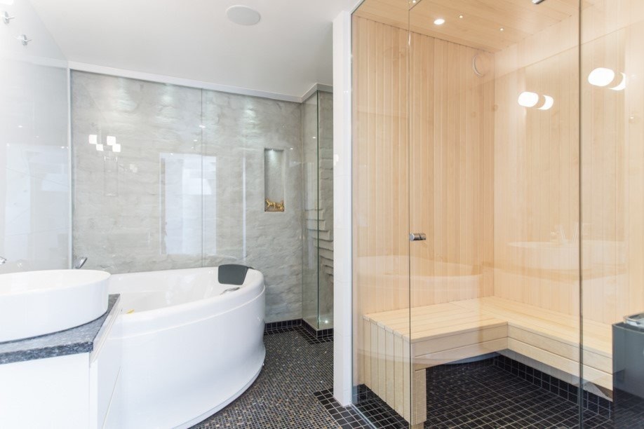 Exempel på ett mellanstort modernt badrum med dusch, med släta luckor, vita skåp, en jacuzzi, en öppen dusch, en vägghängd toalettstol, vit kakel, kakel i småsten, vita väggar, mosaikgolv, ett fristående handfat, granitbänkskiva, svart golv och dusch med gångjärnsdörr