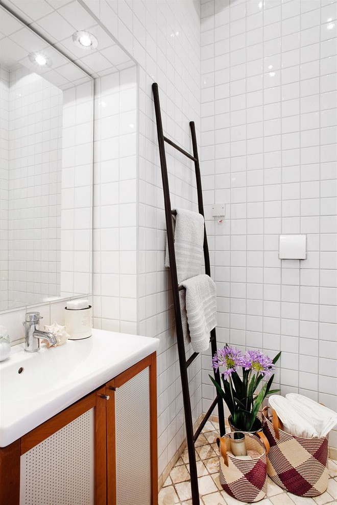 Mittelgroßes Modernes Badezimmer mit Schrankfronten im Shaker-Stil, beigen Fliesen, weißen Fliesen, weißer Wandfarbe, integriertem Waschbecken, Porzellanfliesen und Keramikboden in Stockholm