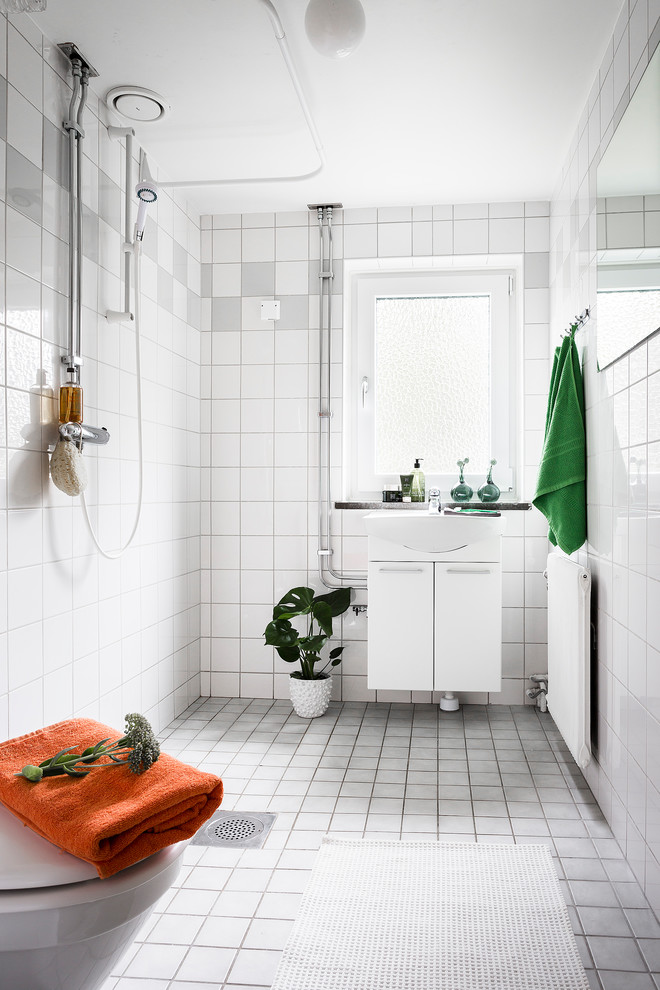 ストックホルムにある北欧スタイルのおしゃれなバスルーム (浴槽なし) (白いキャビネット、オープン型シャワー、白い壁、グレーの床、オープンシャワー、フラットパネル扉のキャビネット) の写真