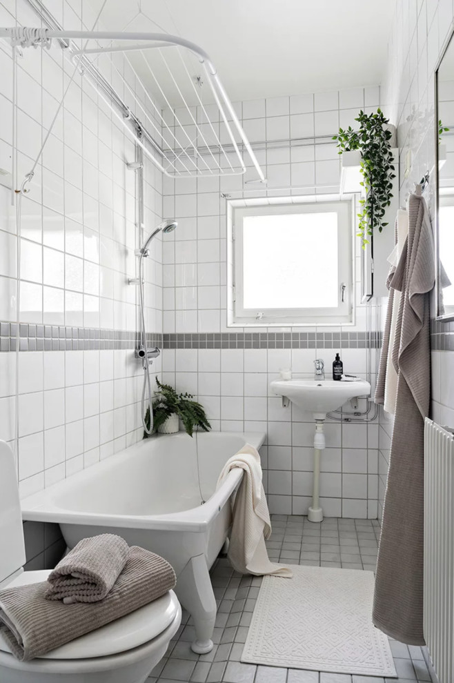 Idéer för små nordiska badrum med dusch, med ett badkar med tassar, en toalettstol med hel cisternkåpa, flerfärgad kakel, porslinskakel, flerfärgade väggar, klinkergolv i porslin, ett väggmonterat handfat och grått golv