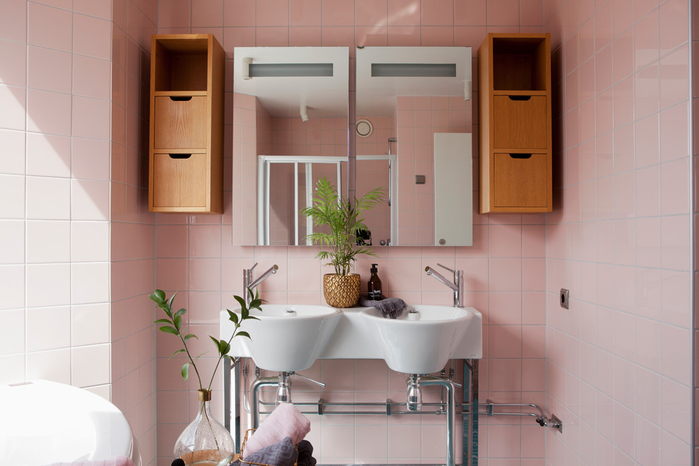 Diseño de cuarto de baño escandinavo con armarios con paneles lisos, puertas de armario de madera oscura, baldosas y/o azulejos rosa, baldosas y/o azulejos de porcelana, paredes rosas y lavabo suspendido