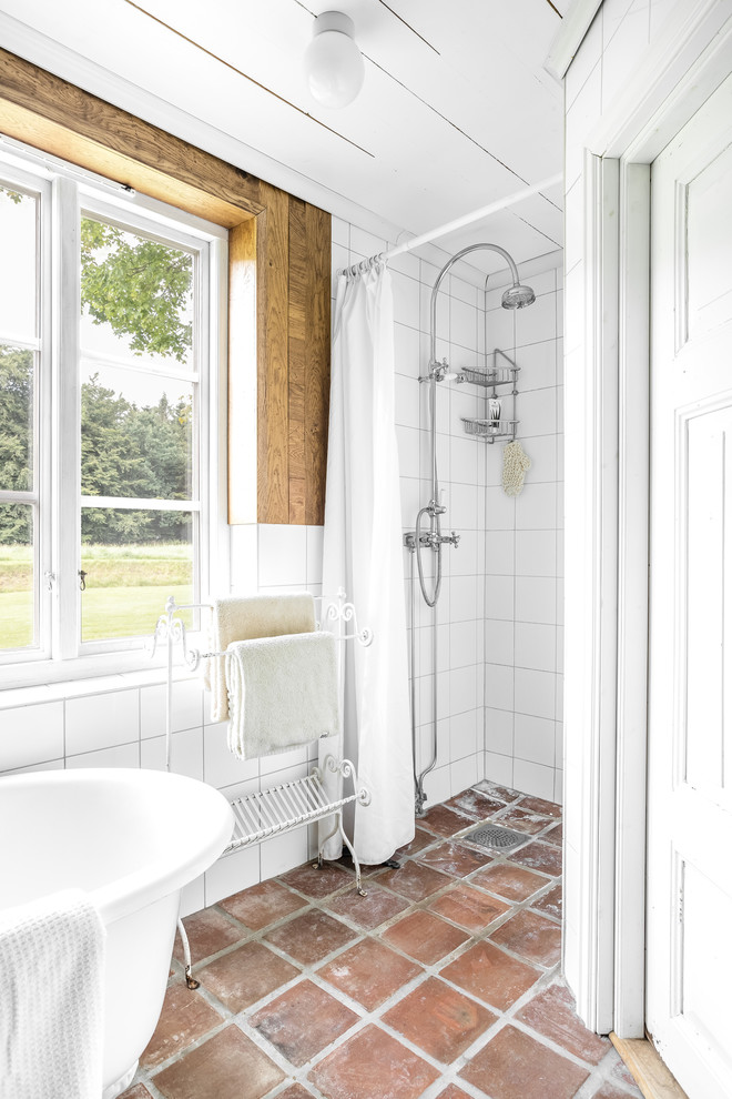 Bild på ett lantligt badrum, med klinkergolv i terrakotta och brunt golv