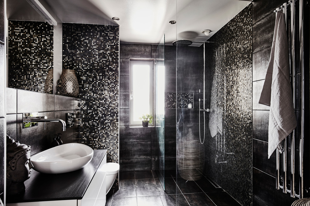 На фото: большая ванная комната в современном стиле с плоскими фасадами, белыми фасадами, угловым душем, черной плиткой, плиткой мозаикой, черными стенами, полом из известняка, душевой кабиной, столешницей из дерева, открытым душем и черным полом