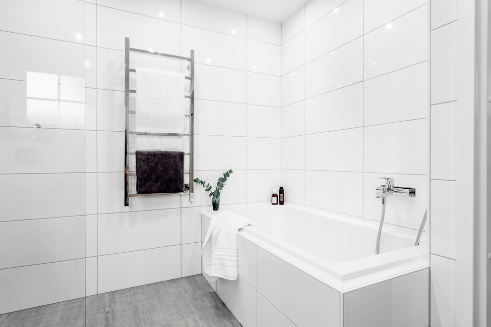 На фото: большая главная ванная комната в скандинавском стиле с плоскими фасадами, светлыми деревянными фасадами, душем в нише, унитазом-моноблоком, белой плиткой, керамогранитной плиткой, белыми стенами, полом из известняка, накладной раковиной, серым полом и открытым душем