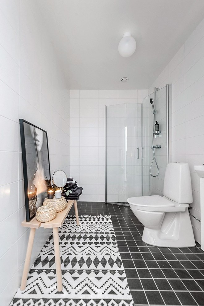 Exempel på ett minimalistiskt badrum med dusch, med vita skåp, våtrum, en toalettstol med separat cisternkåpa, vit kakel, keramikplattor, vita väggar och svart golv
