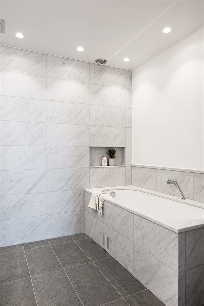 Стильный дизайн: серо-белая ванная комната среднего размера в стиле модернизм с открытыми фасадами, полновстраиваемой ванной, серой плиткой, серыми стенами и полом из известняка - последний тренд