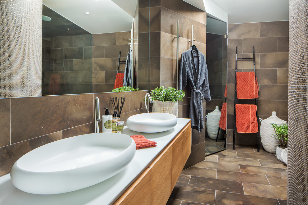 На фото: главная ванная комната среднего размера в современном стиле с плоскими фасадами, светлыми деревянными фасадами, керамической плиткой, коричневыми стенами и настольной раковиной с