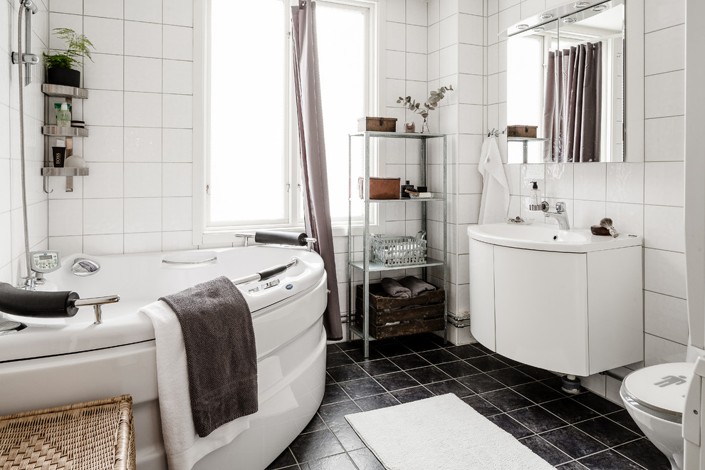 Источник вдохновения для домашнего уюта: ванная комната среднего размера в современном стиле с плоскими фасадами, белыми фасадами, угловой ванной, душем над ванной, керамогранитной плиткой, белыми стенами, полом из известняка, накладной раковиной и шторкой для ванной