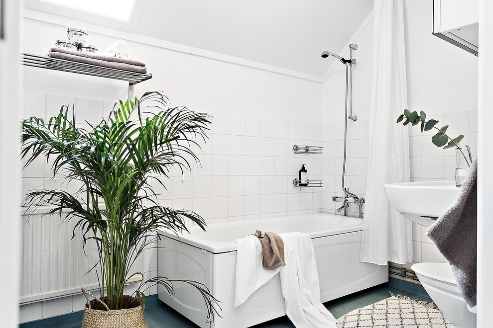 Immagine di una stanza da bagno padronale nordica con vasca ad angolo, vasca/doccia, piastrelle bianche, pareti bianche, pavimento blu e doccia con tenda