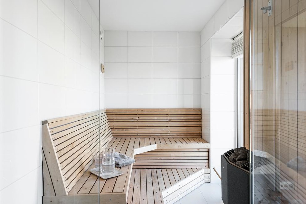 Inredning av ett skandinaviskt badrum, med vit kakel och vitt golv