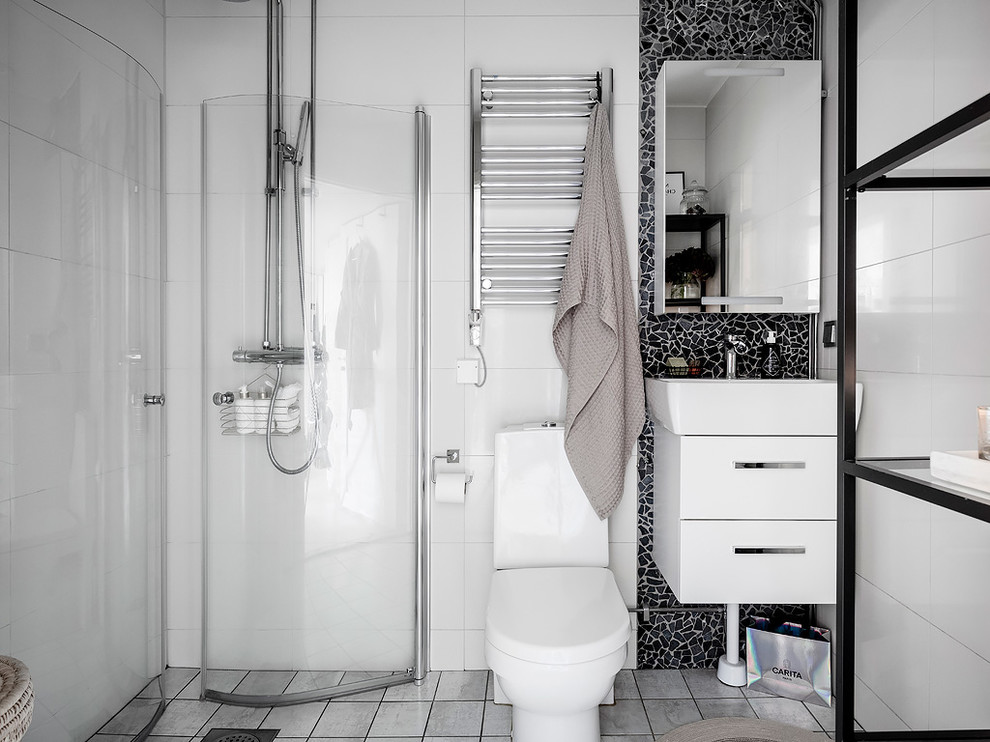 Inspiration för ett nordiskt badrum med dusch, med släta luckor, vita skåp, en hörndusch, en toalettstol med hel cisternkåpa, svart kakel, mosaik, vita väggar, ett konsol handfat, grått golv och dusch med gångjärnsdörr