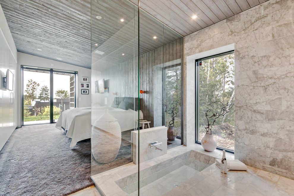 Inredning av ett modernt stort en-suite badrum, med ett platsbyggt badkar, en hörndusch, en vägghängd toalettstol, marmorkakel, marmorgolv, marmorbänkskiva och med dusch som är öppen